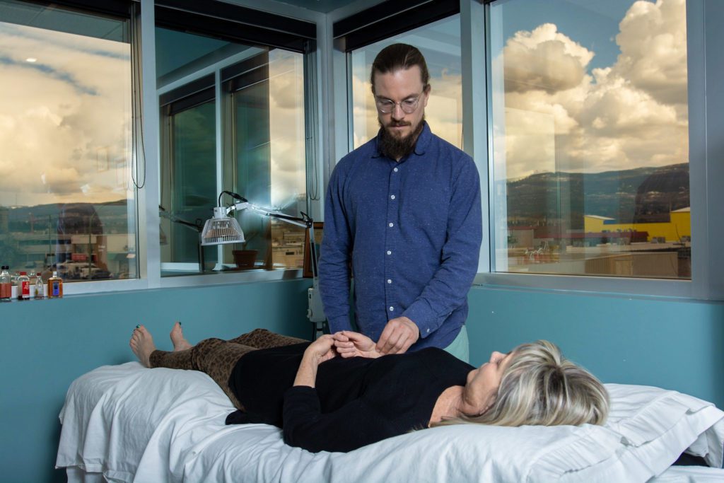 professional performing acupuncture for a client on their hand